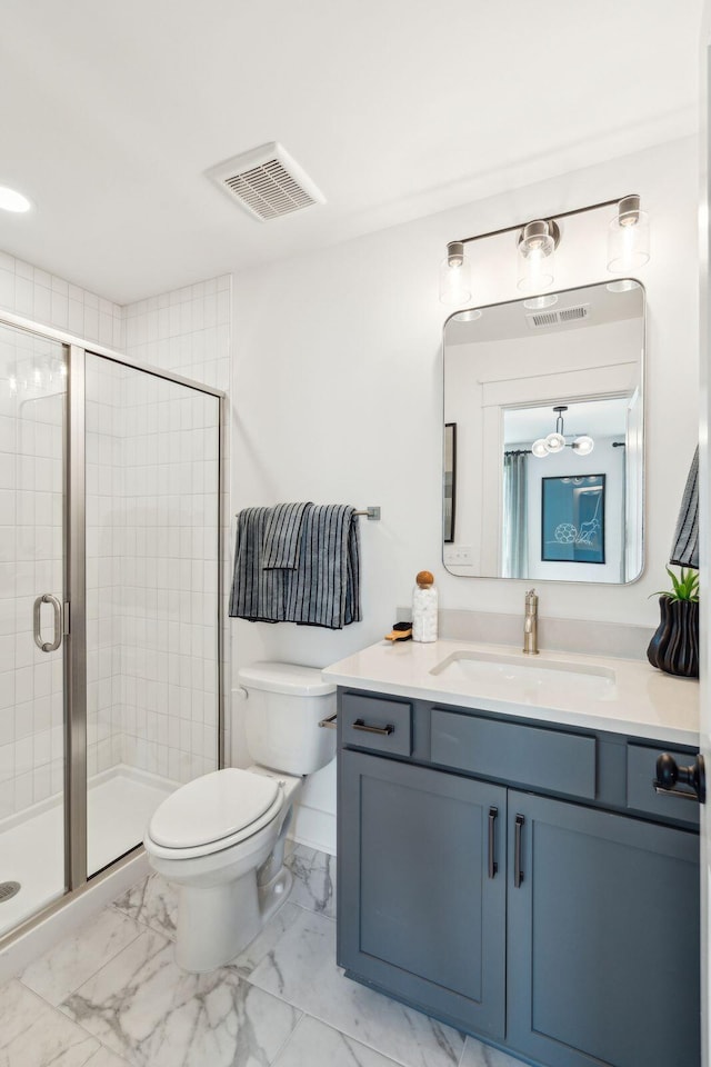 bathroom featuring toilet, vanity, and a shower with door