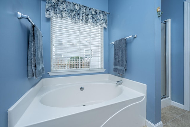 bathroom with tile patterned flooring, a shower stall, and a bath