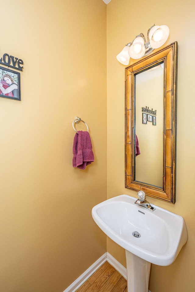 bathroom featuring a sink, wood finished floors, and baseboards