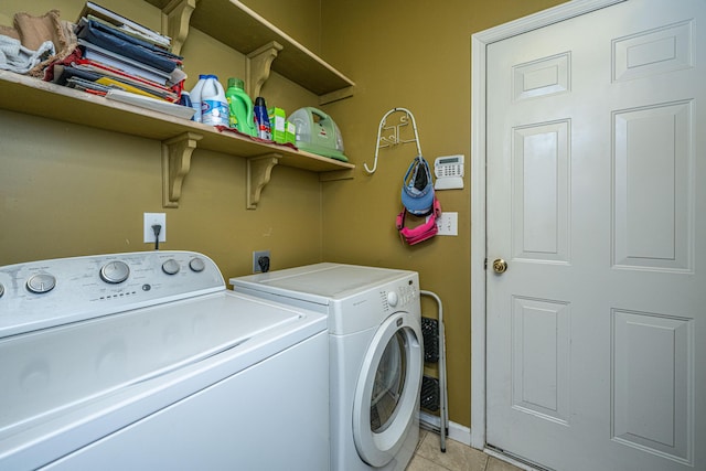 washroom with laundry area, light tile patterned floors, baseboards, and washer and dryer