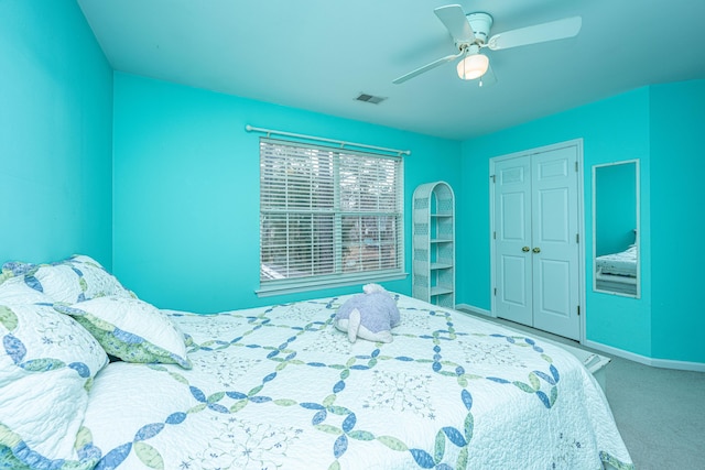 carpeted bedroom featuring ceiling fan, a closet, visible vents, and baseboards