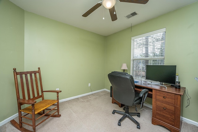 office space with light colored carpet, visible vents, ceiling fan, and baseboards