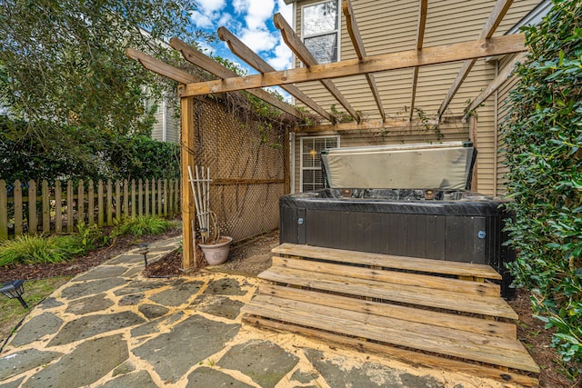 view of patio / terrace featuring a pergola, fence, and a hot tub