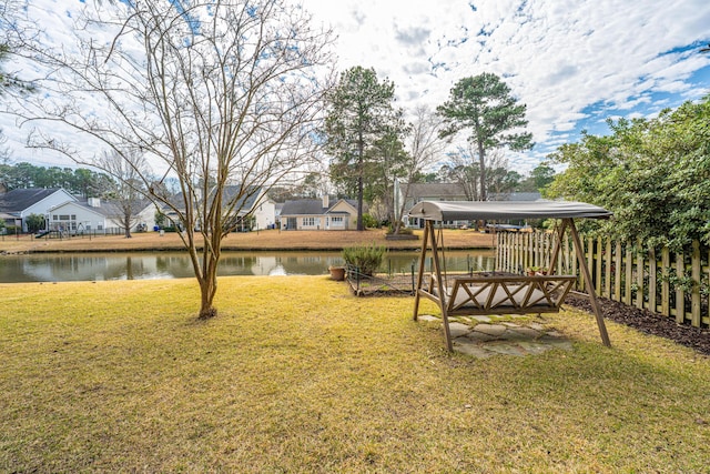 view of yard with a water view and fence