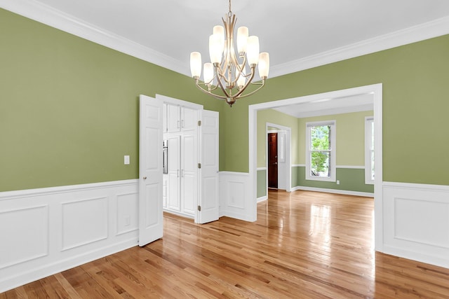 320 Compton Xing, Summerville, SC 29485 - unfurnished dining area with ornamental molding, a chandelier, wainscoting, light wood-style flooring, and a decorative wall