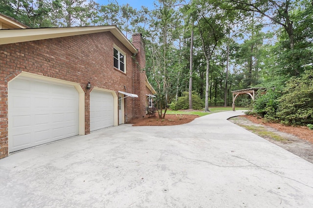 320 Compton Xing, Summerville, SC 29485 - view of side of home with driveway, brick siding, a chimney, and a garage