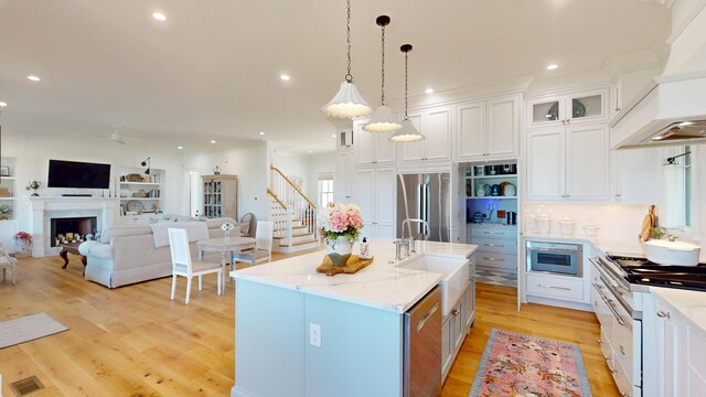 2312 Rushland Landing Rd, Johns Island, SC 29455 - kitchen with appliances with stainless steel finishes, a sink, custom exhaust hood, open floor plan, and light wood-type flooring