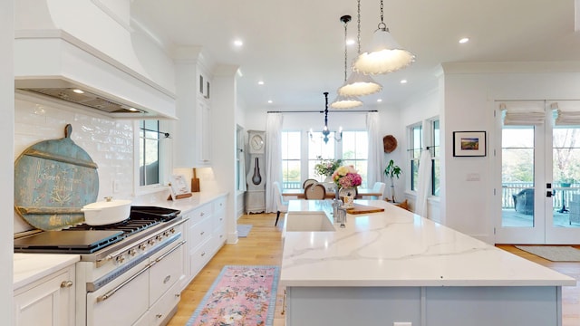 2312 Rushland Landing Rd, Johns Island, SC 29455 - kitchen featuring premium range hood, a kitchen island with sink, tasteful backsplash, white cabinets, and a chandelier