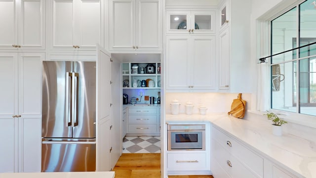 2312 Rushland Landing Rd, Johns Island, SC 29455 - kitchen with stainless steel appliances, white cabinetry, light stone countertops, glass insert cabinets, and light wood-style flooring