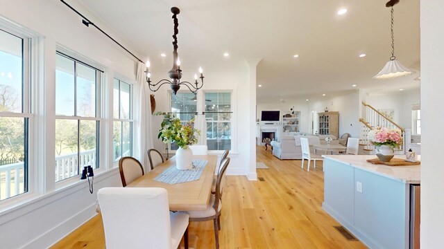 2312 Rushland Landing Rd, Johns Island, SC 29455 - dining area featuring a chandelier, recessed lighting, light wood-style floors, a fireplace, and baseboards