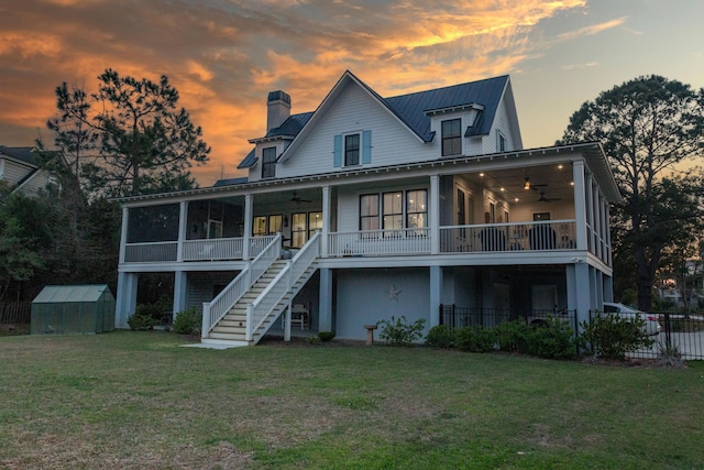 2312 Rushland Landing Rd, Johns Island, SC 29455 - back of house at dusk with ceiling fan, an exterior structure, an outdoor structure, stairway, and a chimney