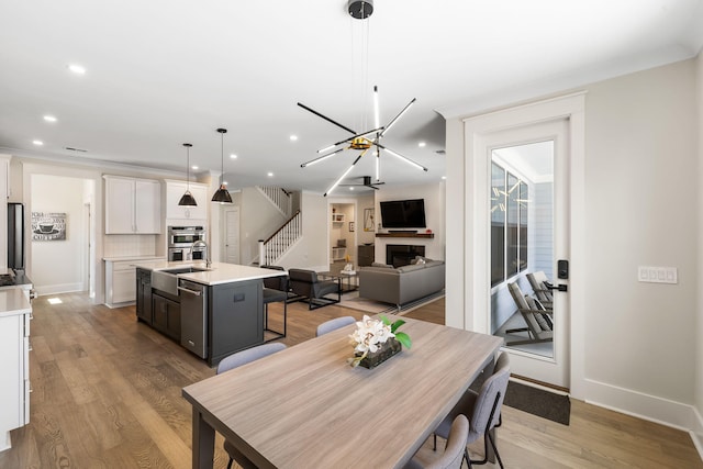 1234 Captain Rivers Dr, Charleston, SC 29412 - dining space with stairway, a fireplace, a chandelier, baseboards, and recessed lighting