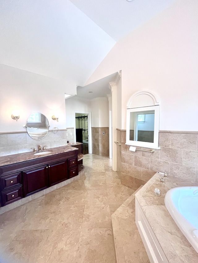 full bathroom with lofted ceiling, vanity, tile walls, and a bath