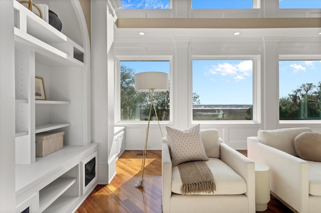 living area featuring visible vents, a high ceiling, and wood finished floors