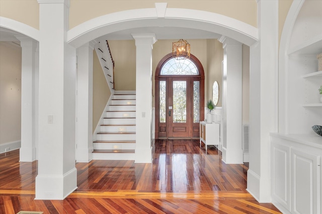 entryway with stairway, baseboards, arched walkways, and hardwood / wood-style floors