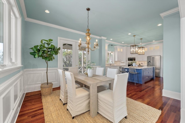 dining area with ornamental molding, a chandelier, dark wood-type flooring, and recessed lighting