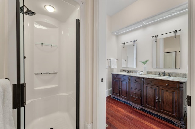 bathroom featuring a sink, a shower stall, and wood finished floors