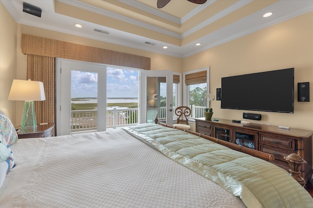 bedroom featuring ornamental molding, a raised ceiling, visible vents, and access to exterior