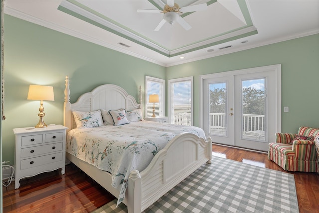 bedroom featuring access to exterior, a tray ceiling, ornamental molding, and wood finished floors