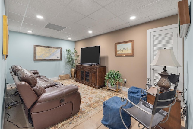 living area with a drop ceiling, recessed lighting, and baseboards