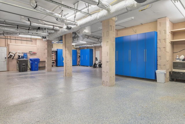 garage featuring concrete block wall and a garage door opener