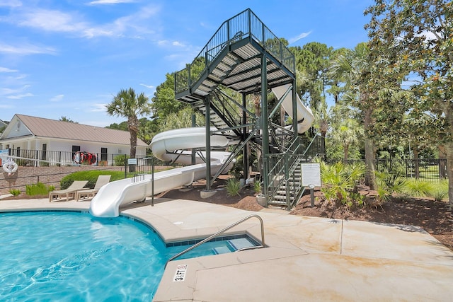 community pool featuring a water slide, fence, stairway, and a patio