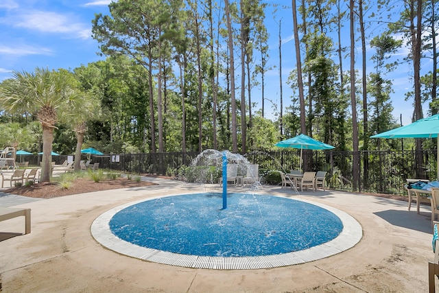 view of swimming pool featuring a patio area and fence