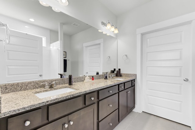 full bathroom featuring a sink, visible vents, double vanity, and tile patterned floors