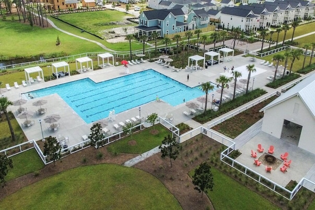 community pool with a residential view, fence, and a patio area