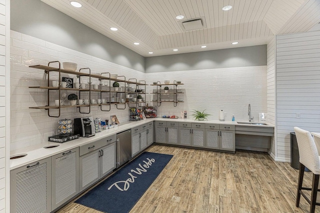 bar featuring light wood-type flooring, visible vents, a sink, fridge, and wooden ceiling