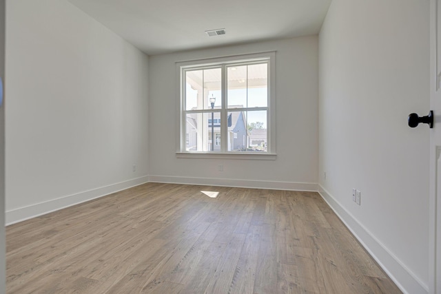 unfurnished room with visible vents, baseboards, and wood finished floors