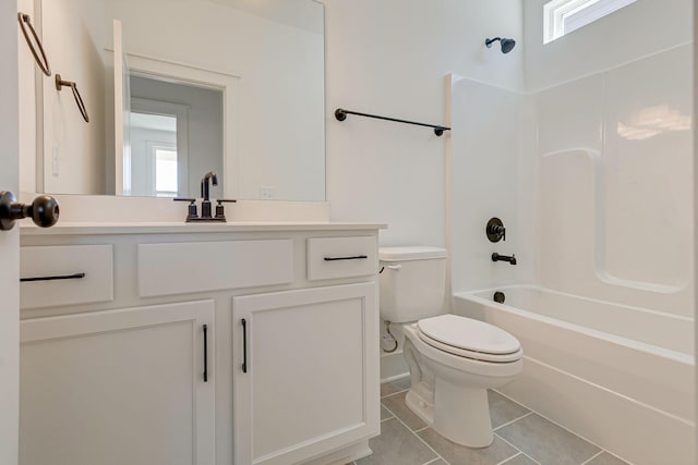 bathroom with tub / shower combination, toilet, vanity, and tile patterned flooring