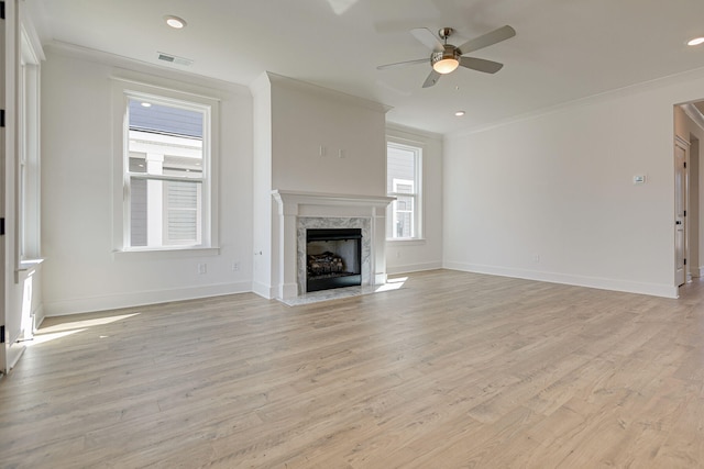 unfurnished living room featuring ceiling fan, a fireplace, light hardwood / wood-style floors, and ornamental molding