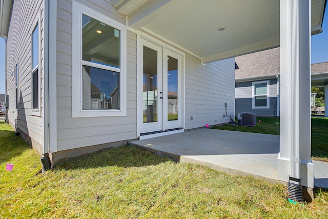 entrance to property featuring a patio, a yard, and central AC unit