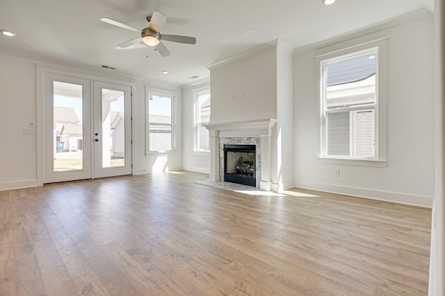 unfurnished living room with visible vents, light wood-style floors, ornamental molding, and a ceiling fan