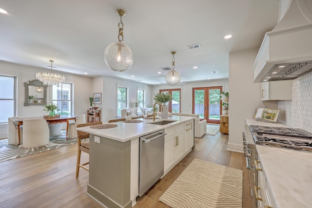 974 Cliffwood Dr, Mount Pleasant, SC 29464 - kitchen with stainless steel dishwasher, a sink, premium range hood, light wood finished floors, and white cabinetry