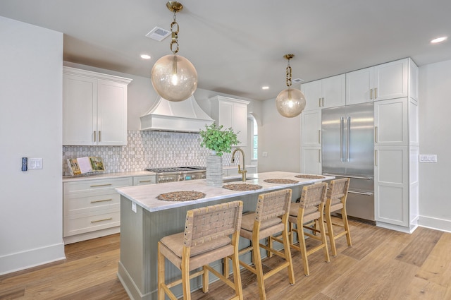 974 Cliffwood Dr, Mount Pleasant, SC 29464 - kitchen featuring stainless steel built in refrigerator, tasteful backsplash, light countertops, a kitchen island with sink, and white cabinets
