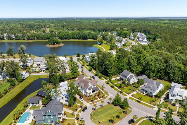 aerial perspective of suburban area with a heavily wooded area and a nearby body of water