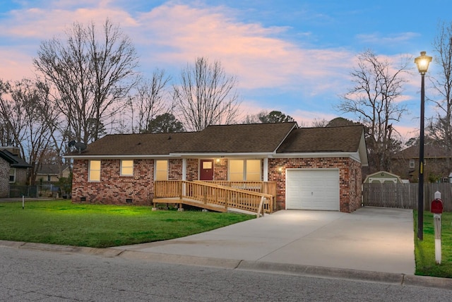 ranch-style home with a garage, a yard, and a deck