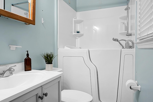 bathroom with vanity, toilet, and a tub