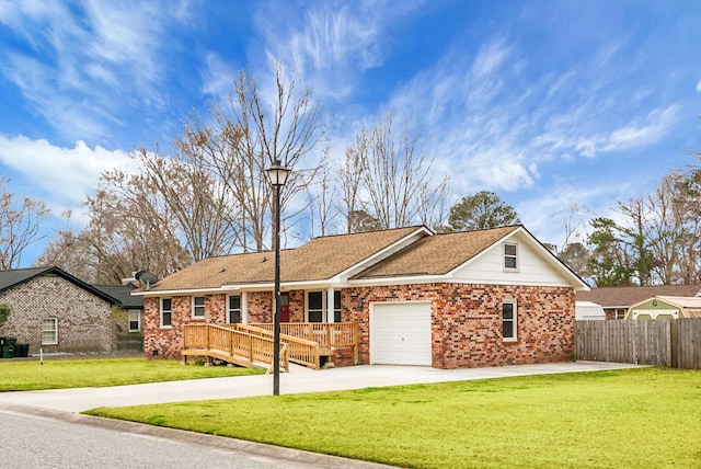 ranch-style home featuring a garage, a front yard, and a deck