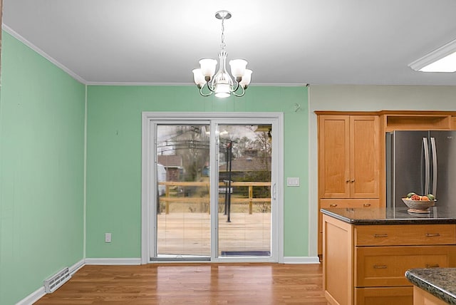 interior space featuring a chandelier, visible vents, baseboards, ornamental molding, and light wood-type flooring