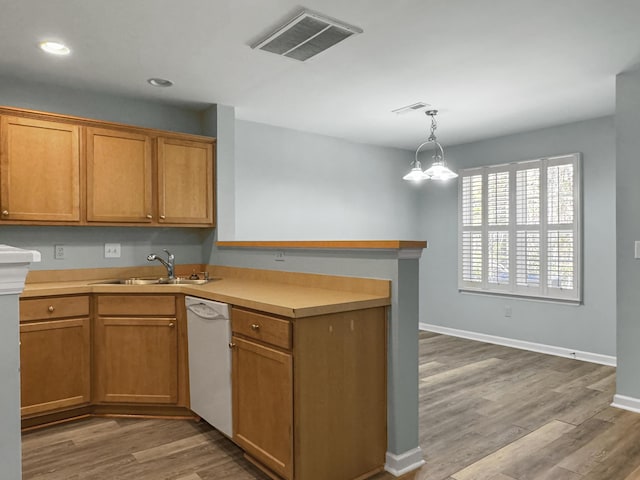 kitchen with light countertops, white dishwasher, a sink, and visible vents