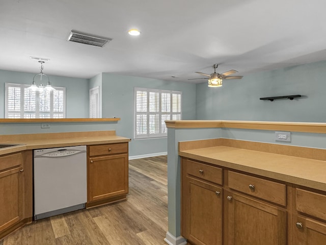 kitchen with pendant lighting, brown cabinets, light countertops, visible vents, and dishwasher