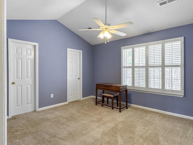 interior space with vaulted ceiling, baseboards, a ceiling fan, and light colored carpet