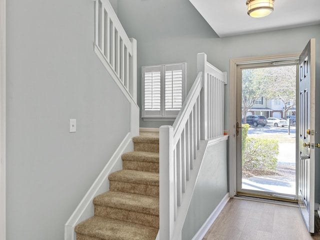 entrance foyer featuring light wood-style floors, stairway, and baseboards