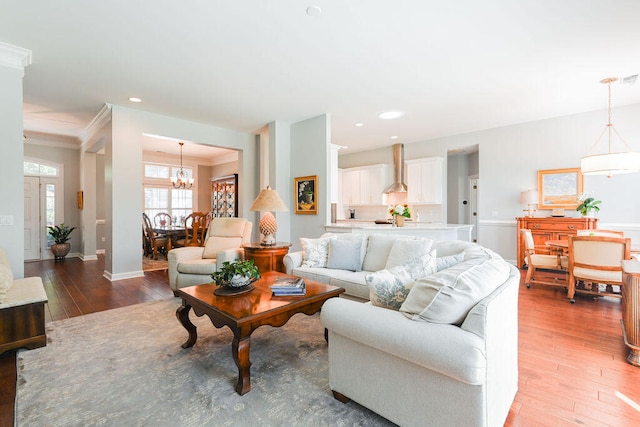 living room with ornamental molding, a notable chandelier, and dark hardwood / wood-style flooring