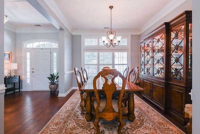 dining room with an inviting chandelier, crown molding, and dark hardwood / wood-style floors