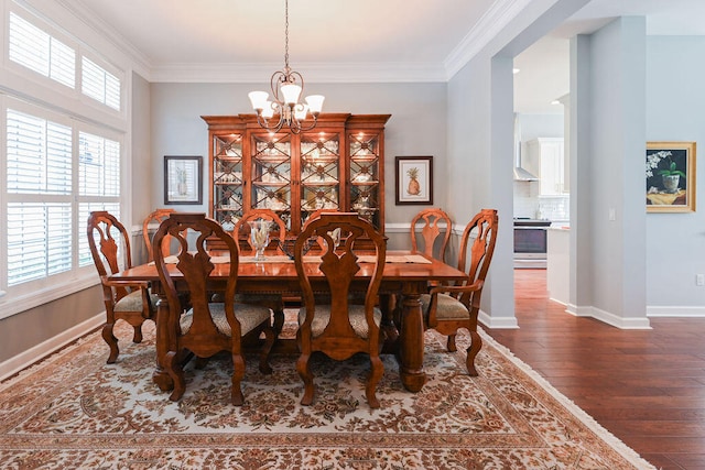 dining room featuring ornamental molding, an inviting chandelier, and dark wood-type flooring