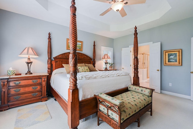 carpeted bedroom with a raised ceiling and ceiling fan